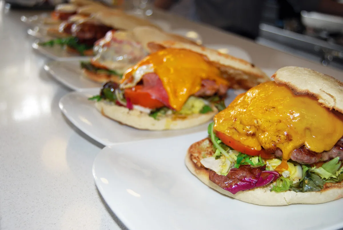 Dues hamburgueses obertes amb cheddar fos, enciam i tomàquet